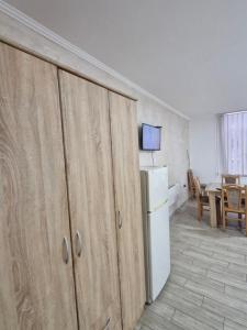 a kitchen with wooden cabinets and a white refrigerator at Konak Kod Gorana 1 in Subotica