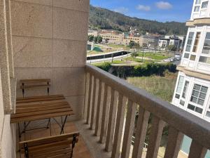 a balcony with a bench and a view of a city at RÍA LIVING - Calma 02 in Cee