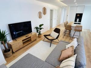 a living room with a couch and a flat screen tv at RÍA LIVING - Calma 02 in Cee