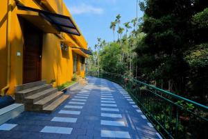 an empty street next to a yellow building at By the stream resort wayanad in Padinjarathara