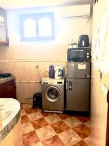 a washer and dryer in a room with a tile floor at Appartement confort et sérénité in Ikhorbane