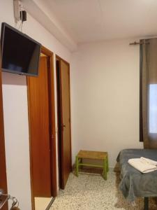 a room with a bed and a flat screen tv at Hostal Collsacabra in L’ Esquirol