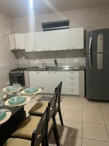 a kitchen with a table and chairs and a refrigerator at Casa AGV 77 - Gaibu Beach in Cabo de Santo Agostinho