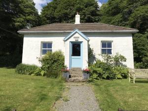 a small white house with a blue door at South Lodge in Lochgilphead