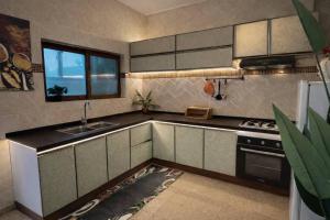a kitchen with a sink and a stove at Kaz An Nou in Cotonou