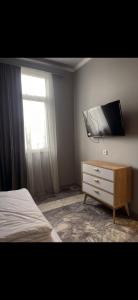 a bedroom with a bed and a tv on a wall at The Corner Hotel in Yerevan