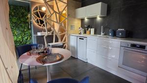 eine Küche mit einem Tisch, auf dem Weingläser stehen in der Unterkunft Maison Triangle in Saint-Alban-dʼAy
