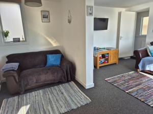 a living room with a brown couch and a table at Firthview House great for families with children pet friendly in Kirn +61 photos