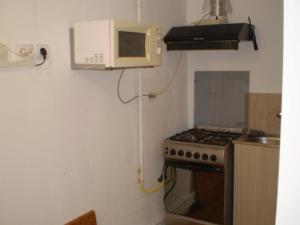 a kitchen with a stove and a microwave at apartament MIHAI in Mangalia