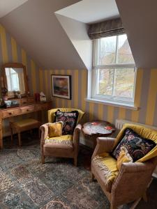 a living room with two chairs and a table at Clachan Garden B&B in Garve