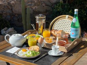 a picnic table with breakfast foods and a bottle of wine at La Casa Occitane in Marseillan