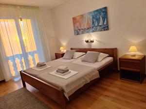a bedroom with a bed with two towels on it at Apartments and Rooms Vinko in Barbat na Rabu