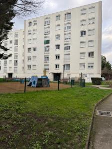 an apartment building with a playground in front of it at Apparemment 2 pièces in Vaulx-en-Velin