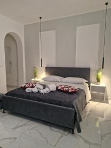 a bedroom with a large bed with two stuffed animals on it at Dolce Giò A in Mazara del Vallo