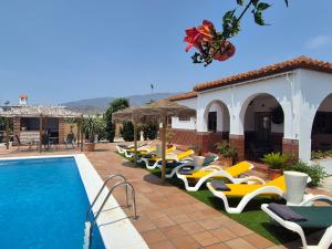 a row of lounge chairs next to a swimming pool at Villa Florida in Motril