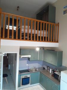 a kitchen with green cabinets and a bunk bed at Appartement Stella plage in Cucq +4 photos