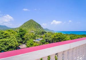 a balcony with a view of the ocean and mountains at Scarlett Near Cane River Falls in Bull Bay