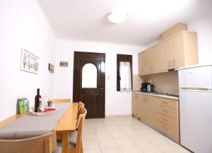 a kitchen with a dining table and a kitchen with white appliances at MaGia Peristeridi in Polychrono