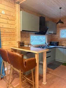 a kitchen with a table and chairs in a cabin at Samlaun Chalet and Retreat in Kanatal +28 photos