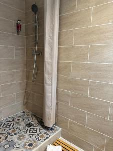a bathroom with a shower with a tile wall at Hôtel Abalone - Centre Gare in Nîmes +68 photos