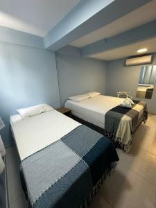 two beds in a room with blue walls at Pousada Encantos do Mar in Barra de Camaratuba +19 photos