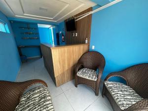 a room with two wicker chairs and a counter at Pousada Encantos do Mar in Barra de Camaratuba
