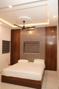 a bedroom with a bed with a ceiling fan at Mountain Mist Ranipuram in Kallar