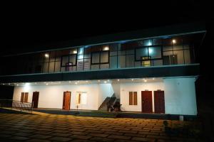 a building with lights on it at night at Mountain Mist Ranipuram in Kallar +6 photos