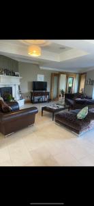 a large living room with couches and a piano at Birchall Lodge in Galway