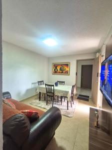 a living room with a table and chairs and a television at Diamante em Brasília in Brasília