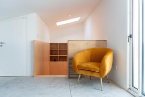 a yellow chair in a room with a closet at The Lookout | Private Beach Access in São Roque