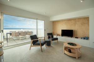 a living room with a view of the ocean at The Lookout | Private Beach Access in São Roque
