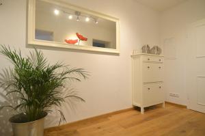 a room with a mirror and a dresser and a plant at Ringpark-Ferien in Würzburg