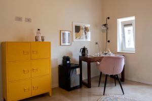 a room with a desk and a yellow cabinet and a chair at La Dimora del Pensatore - country escape Noto in Canicattini Bagni