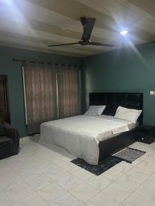 a bedroom with a bed with a ceiling fan at Macdel Guesthouse And Condos in Kumasi +5 photos