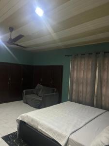 a bedroom with two beds and a ceiling at Macdel Guesthouse And Condos in Kumasi