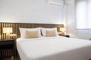 a bedroom with a large white bed with two lamps at Central Torremolinos Luxury Apartment in Torremolinos