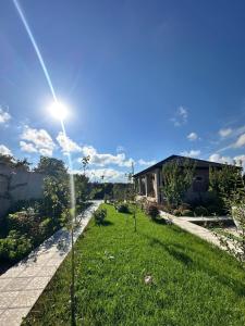 a grassy yard with a street light and a house at Mini Villa in Tel