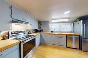 a kitchen with white cabinets and stainless steel appliances at Shore Pine Cottage in Grayland