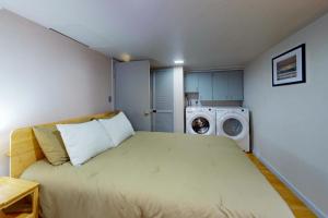 a bedroom with a bed and a washing machine at Shore Pine Cottage in Grayland