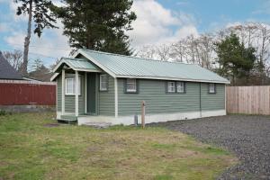 a green house with a green roof in a yard at Shore Pine Cottage in Grayland