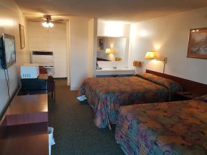 a hotel room with two beds and a sink at Shamrock Motel in Valleyview