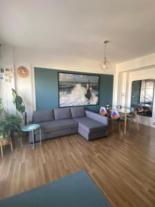 a living room with a couch and a painting on the wall at Blue Zen beachfront apartment in Civitanova Marche