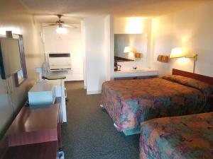 a hotel room with two beds and a desk at Shamrock Motel in Valleyview