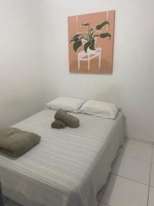 a bed in a room with a painting on the wall at Comendador flats350 in Maceió