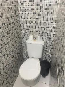 a bathroom with a white toilet in a tiled wall at Comendador flats350 in Maceió