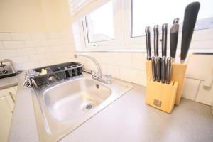 a kitchen sink with knives in a knife block at 1 Bedroom Apartment By Travel Lets Holiday Homes Derry Beside The City Walls in Derry Londonderry +48 photos