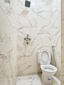 a bathroom with a toilet and marble walls at Blue Pearl Surf & Yoga House in Tamraght Ou Fella +177 photos