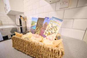 a basket filled with ice cream and books on a counter at 1 Bedroom Apartment By Travel Lets Holiday Homes Derry Beside The City Walls in Derry Londonderry