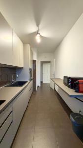 an empty kitchen with white cabinets and a sink at Urban Nest Living in Sesto San Giovanni +1 photo